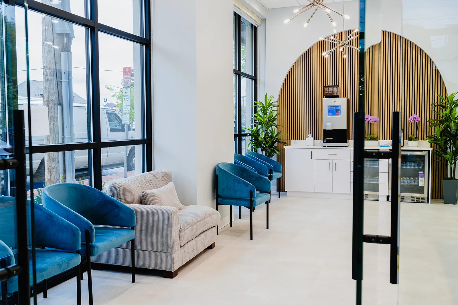 Dental 365 waiting lounge with blue seating and wood-slat feature wall