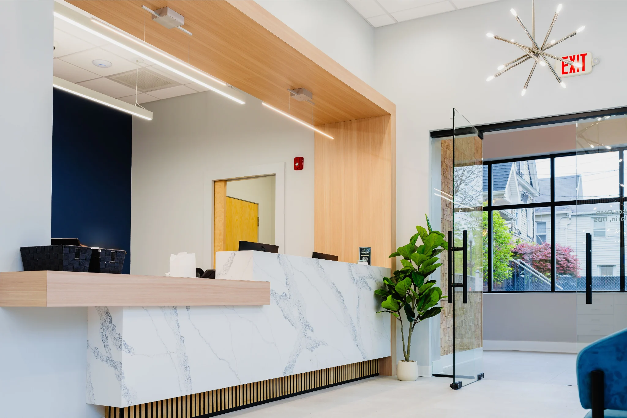 Dental 365 reception desk with warm wood and marble finishes